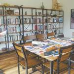 At an open house for the Storyknife Writers Retreat on Monday, Aug. 29, Storyknife board member Patty Stith looks at one of the books published by past Storyknife fellows in the library of Eva, the main house for the retreat near Homer.
