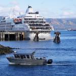 A fishing boat passes the Silversea cruise ship Silver Wind as the boat enters the Homer Harbor on Sunday, Sept. 25, 2022, in Homer, Alaska. (Photo by Michael Armstrong/Homer News)