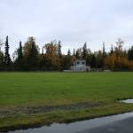 Nikiski Middle/High School Principal Shane Bostic stands near a track and field long jump sand pit on Monday, Sept. 19, 2022, in Nikiski, Alaska. The track is one of several projects in a bond package Kenai Peninsula voters will consider during the Oct. 4 municipal election next month. (Ashlyn OHara/Peninsula Clarion)