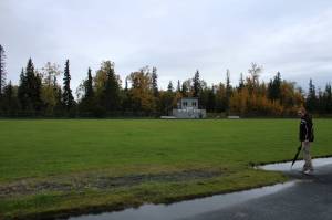 Nikiski Middle/High School Principal Shane Bostic stands near a track and field long jump sand pit on Monday, Sept. 19, 2022, in Nikiski, Alaska. The track is one of several projects in a bond package Kenai Peninsula voters will consider during the Oct. 4 municipal election next month. (Ashlyn OHara/Peninsula Clarion)
