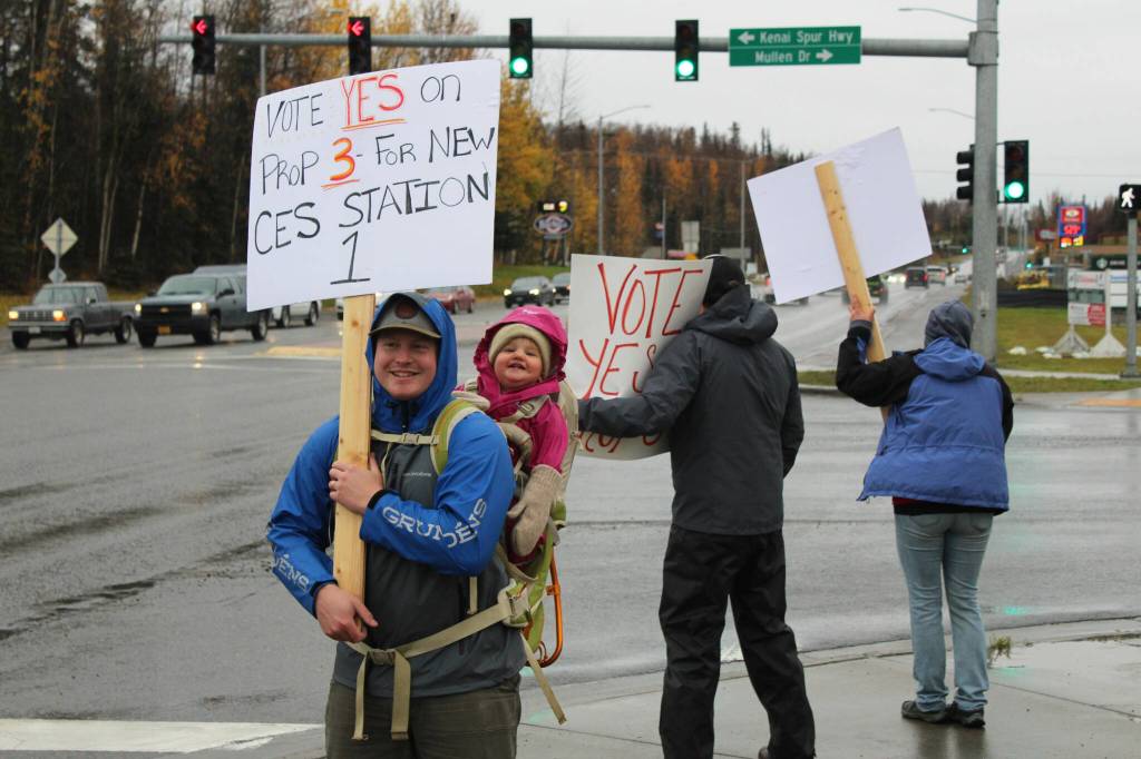 Spencer McLean and his daughter, Emma McLean, show their support for Proposition 3, through which a new CES Station 1 would be constructed in Soldotna, on Tuesday, Oct. 4, 2022, in Soldotna, Alaska. (Ashlyn OHara/Peninsula Clarion)