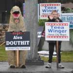 Two kids wave signs for candidates Alex Douthit and Teea Winger on Election Day, Oct. 4, 2022, in Kenai, Alaska. (Jake Dye/Peninsula Clarion)