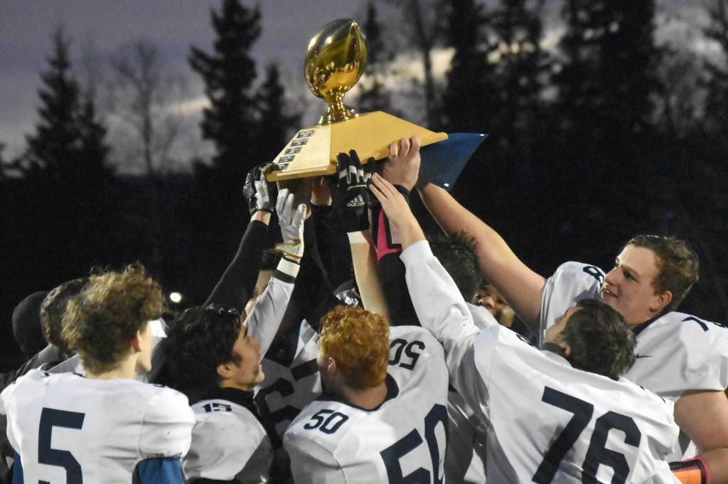Homer hoists the Division III state championship trophy Saturday, Oct. 15, 2022, at Service High School in Anchorage, Alaska. (Photo by Jeff Helminiak/Peninsula Clarion)