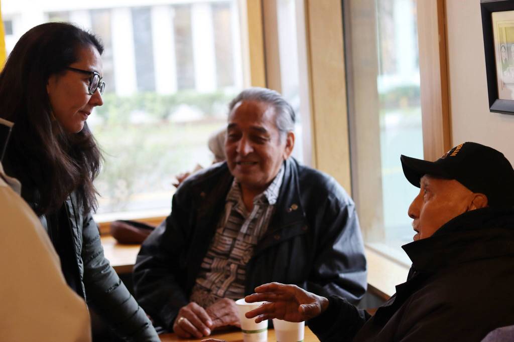 Raymond Wilson, 89, right, tells U.S. Rep. Mary Peltola during a meet-and-greet Tuesday at Coppa he plans to perform a ceremony invoking the spirit of a Chilkat headdress and robe on display at the Alaska State Museum, and for her to imagine you have the Chilkat blanket around you when they start throwing mud and it will protect you. (Mark Sabbatini / Juneau Empire)
