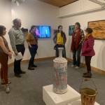 Carla Klinker Cope, far left, and Nadia Jackinski-Sethi, center, co-curators of thethe Pratt Museum & Parks show Salmon Culture: Kachemak Bay Connections, discuss the show in a talk on Friday, Nov. 3, 2022, at the museum. (Photo by Christina Whiting)