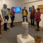 Carla Klinker Cope, far left, and Nadia Jackinski-Sethi, center, co-curators of thethe Pratt Museum & Park's show "Salmon Culture: Kachemak Bay Connections," discuss the show in a talk on Friday, Nov. 3, 2022, at the museum. (Photo by Christina Whiting)