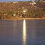 Sun reflected in windows on a house shines on the ice of Beluga Lake on Monday, Nov. 14, 2022, in Homer, Alaska. (Photo by Michael Armstrong/Homer News)