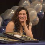 Tela ODonnell-Bacher laughs at a story being told by Neldon Gardner while both were being inducted to the National Wrestling Hall of Fame following the duel wrestling meet on Tuesday, Nov. 22, 2022, at Soldotna High School in Soldotna, Alaska. (Jake Dye/Peninsula Clarion)