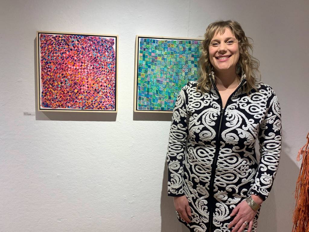 Fairbanks artist Somer Hahm poses with her acrylic on clay board paintings at the opening of the Mother exhibit showing this month at Bunnell Street Arts Center. (Photo by Christina Whiting)