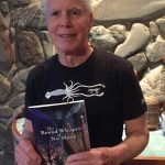 Peter Kaufmann holds a copy of his book of poetry, "The Round Whisper of No Moon." (Photo provided)