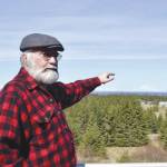 Photo by Victoria Petersen/Peninsula Clarion 
Pete Kineen, a neighbor of the proposed Beachcomber LLC gravel pit, stands on his deck and points to where the pit could be, on May 2, 2019, in Anchor Point, Alaska.