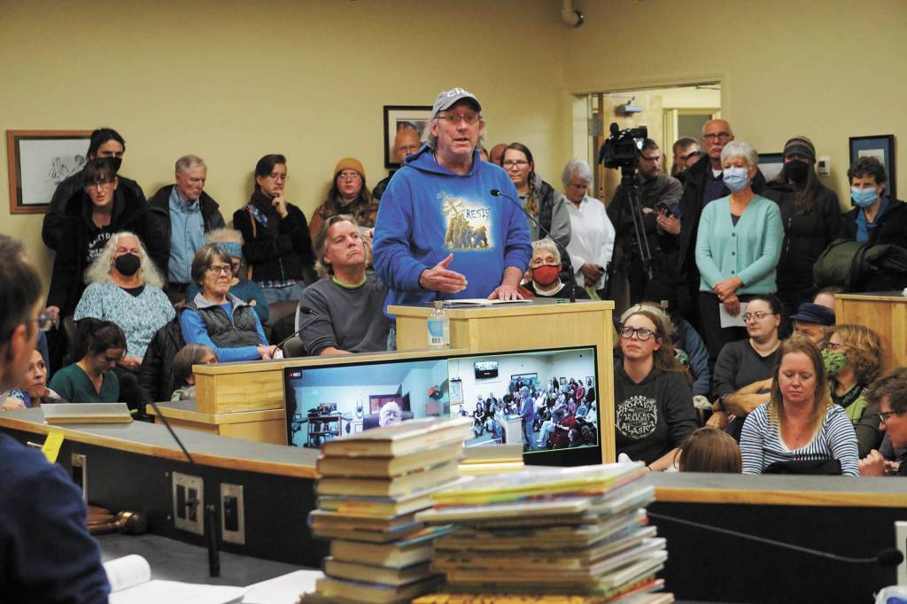 David Lewis speaks atthe meeting of the Library Advisory Board on Nov. 15 in the Cowles Council Chambers at Homer City Hall. A pile of books a citizens group has LGBQT+ content that it has asked to be removed from the childrens section of the Homer Public Library lies on the table in the foreground. (Photo by Michael Armstrong/Homer News)