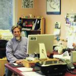Michael Armstrong poses at his desk in February 2015 at the Homer News in Homer. (Photo by McKibben Jackinsky)