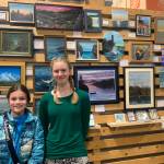 Homer youth artist Leah Dunn, right, and her friend Kyla Palin stand in front of Dunns exhibit during First Friday, on display at Grace Ridge Brewing through January. (Photo by Christina Whiting/Homer News)