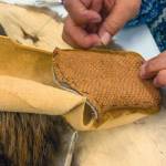 Photo provided 
June Pardue sews a tanned salmon skin vamp onto bison hide with sea otter fur lying beneath.