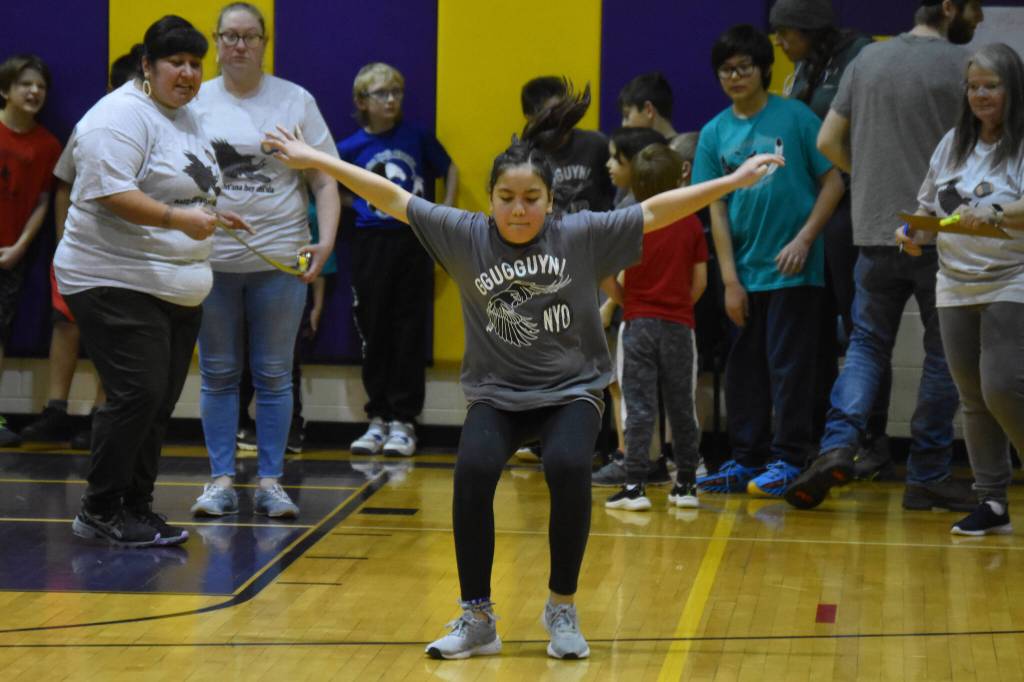 An athlete competing for the Kenaitze Indian Tribe in the Junior division sticks her landing while performing the scissor broad jump during the Kahtnuhtana Hey Chiula NYO Invitational on Frdiay, Jan. 13, 2023, at Kenai Middle School in Kenai, Alaska. (Jake Dye/Peninsula Clarion)