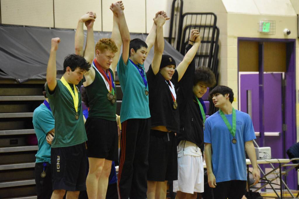 The top five finishers of the wrist carry, including Austin Butler with his gold medal, celebrate together during the Kahtnuhtana Hey Chiula NYO Invitational on Saturday, Jan. 14, 2023, at Kenai Middle School in Kenai, Alaska. (Jake Dye/Peninsula Clarion)