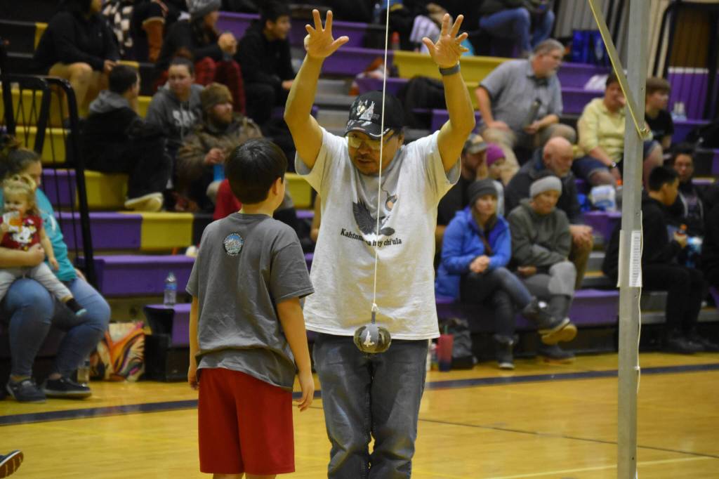 An official gives advice to a junior athlete competing for the Kenaitze Indian Tribe after the boy missed his first attempt at the 2-foot high kick during the Kahtnuhtana Hey Chiula NYO Invitational on Saturday, Jan. 14, 2023, at Kenai Middle School in Kenai, Alaska. (Jake Dye/Peninsula Clarion)