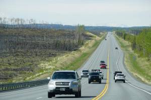 Motorists travel through the Swan Lake fire burn on the Sterling Highway on Sunday, May 22, 2022. (Photo by Michael Armstrong/Homer News)