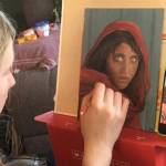 Homer youth artist Leah Dunn works on a painting from the famous 1984 Afghan Girl, originally portrayed on the cover of National Geographic. (Photo provided by Leah Dunn)