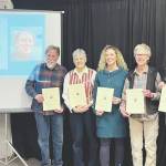 (from left to right) HCOA Community Arts Awardees Daniel Perry (pictured on screen), Michael Armstrong, Cathy Stingley, Krista Etzweiler, Sherry Stead and Brianna Allen pose with their awards at the HCOA annual meeting Friday.