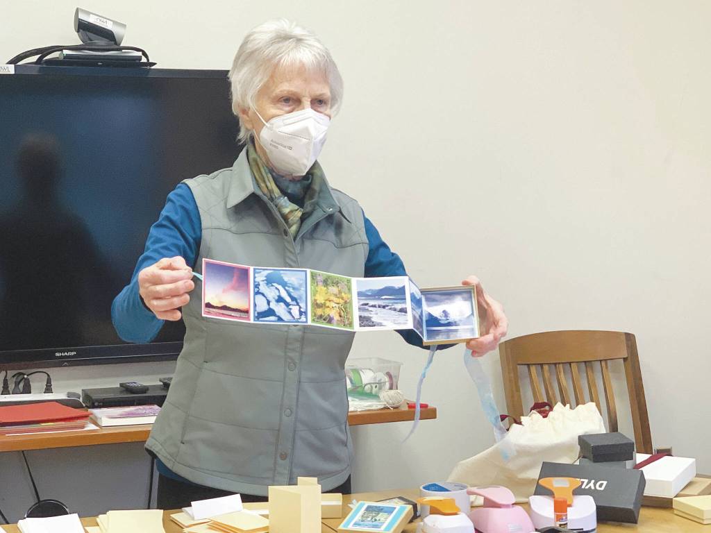 Community member Alice Porter shows an accordian book she made to participants in her class at the library last Saturday. (Photo by Christina Whiting/Homer News)