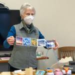 Community member Alice Porter shows an accordian book she made to participants in her class at the library last Saturday. (Photo by Christina Whiting/Homer News)