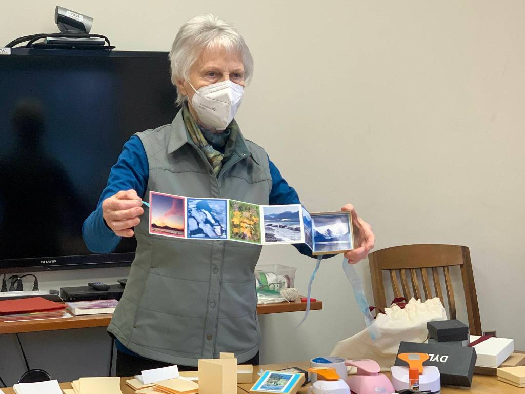 Community member Alice Porter shows an accordian book she made to participants in her class at the library last Saturday. (Photo by Christina Whiting/Homer News)