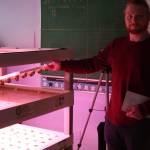 Nikolaevsk School custodian/food service staff John Jones demonstrates the reservoir in the large flood table on Tuesday, Feb. 14, 2023 in the hydroponics room at Nikolaevsk School in Nikolaevsk, Alaska. Photo by Delcenia Cosman