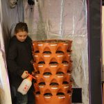 Sixth grader Xanga Miller waters seedlings in the garden tower, donated by secretary Olivia Tipikin, on Tuesday, Feb. 14, 2023 in the hydroponics room at Nikolaevsk School in Nikolaevsk, Alaska. The grow tent that houses the garden tower was donated by parent Ryan Toney. Photo by Delcenia Cosman