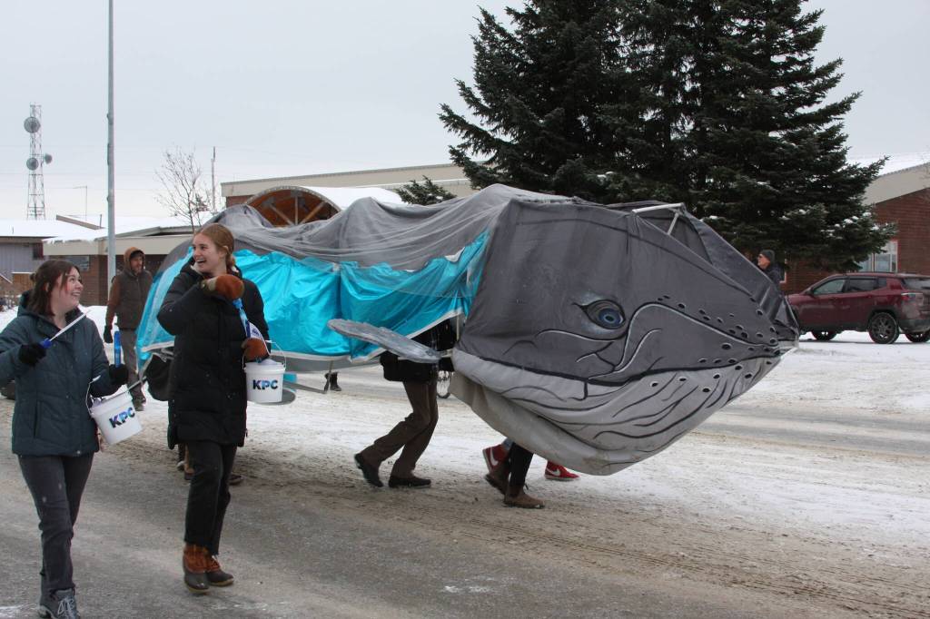 The Kachemak Bay Campus Student Association march with their mascot, Harmony the Whale, down Pioneer Avenue in the 69th Annual Winter Carnival Parade on Saturday, Feb. 11, 2023 in Homer, Alaska. Photo by Delcenia Cosman