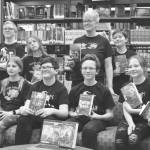 Kenai Middle School Battle of the Books teams, the Reading Rhinoceri and the Guilty GOATs, gather for a photo after their first match during Kenai Peninsula Borough School District Middle School Battle of the Books competiton on Thursday, Feb. 8, 2023, at Kenai Middle School in Kenai, Alaska. (Jake Dye/Peninsula Clarion)