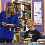 District Librarian Lindsay Hallam listens to a challenge described by Alan Hack and Oscar Marcou during Kenai Peninsula Borough School District Middle School Battle of the Books competition on Thursday, Feb. 9, 2023, at Kenai Middle School in Kenai, Alaska. The challenge would ultimately be declared successful. (Jake Dye/Peninsula Clarion)