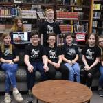 Kenai Middle School Battle of the Books teams, the Reading Rhinoceri and the Guilty GOATs, gather for a photo after their first match during Kenai Peninsula Borough School District Middle School Battle of the Books competition on Thursday, Feb. 9, 2023, at Kenai Middle School in Kenai, Alaska. (Jake Dye/Peninsula Clarion)