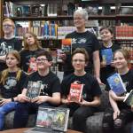 Kenai Middle School Battle of the Books teams, the Reading Rhinoceri and the Guilty GOATs, gather for a photo after their first match during Kenai Peninsula Borough School District Middle School Battle of the Books competition on Thursday, Feb. 9, 2023, at Kenai Middle School in Kenai, Alaska. (Jake Dye/Peninsula Clarion)