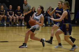 Nikiskis Ember Nelson looks to shoot, closely pursued by Homers Minadora Reutov and Hannah Stonorov during a basketball game on Tuesday Feb. 21, 2023, at Nikiski Middle/High School in Nikiski, Alaska. (Jake Dye/Peninsula Clarion)