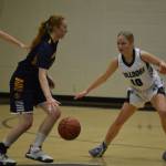 Homers Lawson Alexson dribbles the ball while Nikiskis Avery White moves to defend during a basketball game on Tuesday at Nikiski Middle/High School in Nikiski, Alaska. (Jake Dye/Peninsula Clarion)