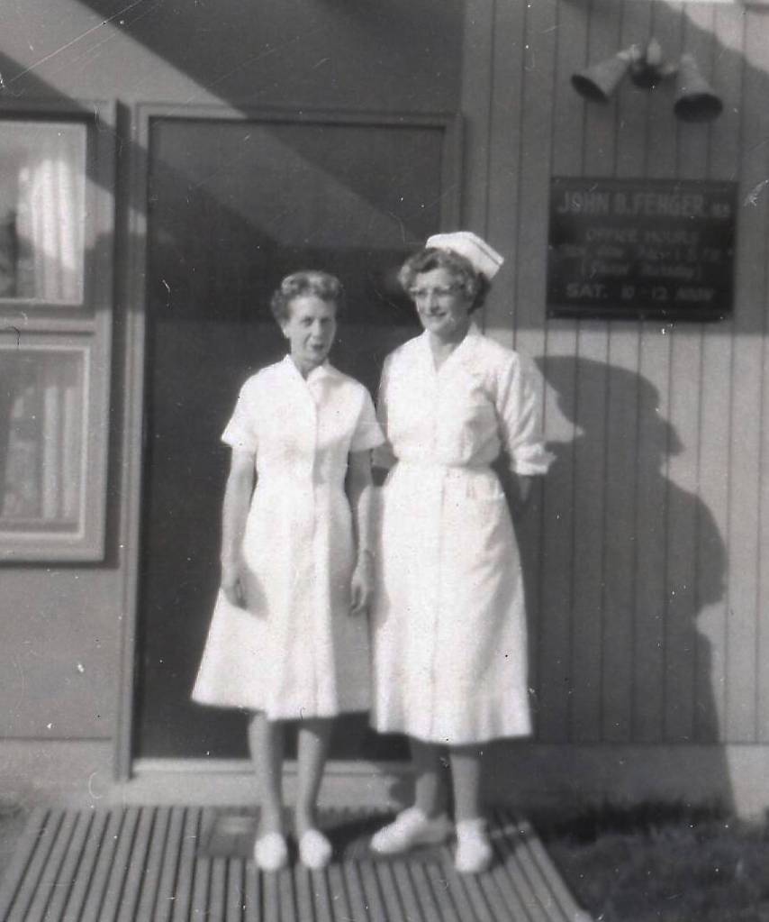 Registered nurses Kay Cowles (wife of Homers first mayor) and Wilma Cowgill pose in the sunshine outside of Dr. John Fengers clinic at the corner of Hohe and Cityview, east of the hospital in Homer. (Photo courtesy of the Fenger Family Collection)