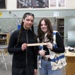 Kenai Central High School freshmen Franchesca Wingster (left) and Olivia McDonald (right) hold a ruler they created in a shop class on Wednesday, Feb. 22, 2023 in Kenai, Alaska (Ashlyn OHara/Peninsula Clarion)