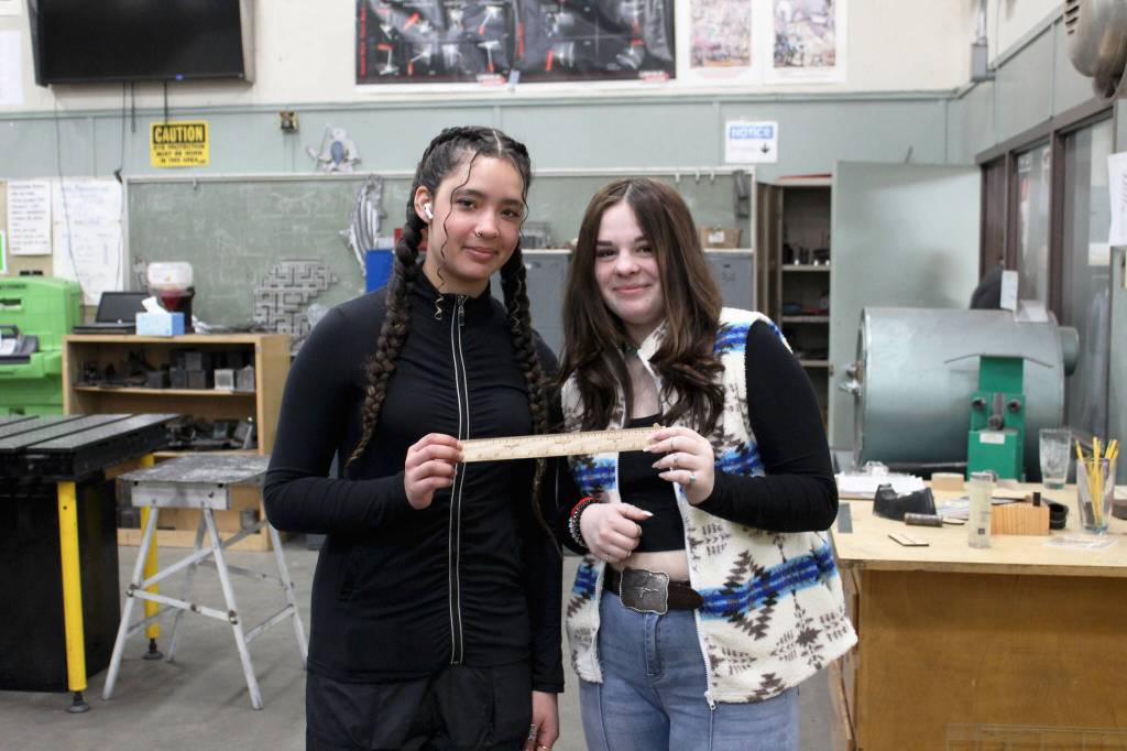 Kenai Central High School freshmen Franchesca Wingster (left) and Olivia McDonald (right) hold a ruler they created in a shop class on Wednesday, Feb. 22, 2023 in Kenai, Alaska (Ashlyn OHara/Peninsula Clarion)