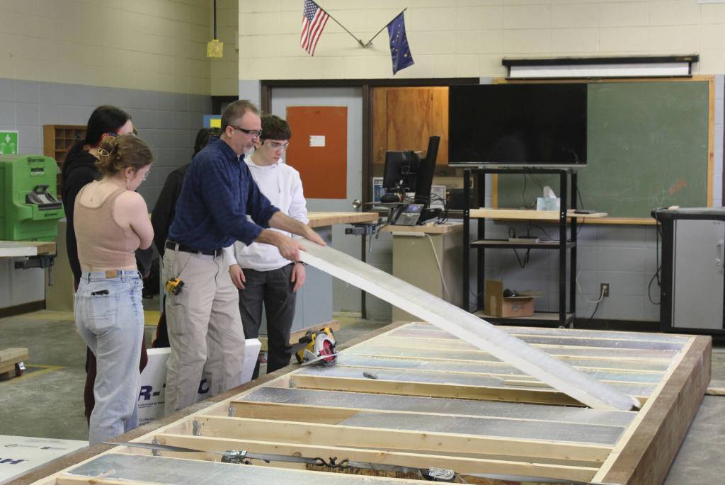 Construction teacher Tim Wight helps students adjust insulation during a class at Soldotna High School on Wednesday, Feb. 22, 2023 in Soldotna, Alaska. (Ashlyn OHara/Peninsula Clarion)