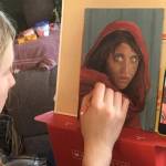 Photo provided by Leah Dunn
Homer youth artist Leah Dunn working on a painting from the famous 1984 Afghan Girl originally portrayed on the cover of National Geographic.