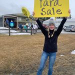 Homer High School freshman Hannah Klima holds a yard sale sign for the fundraiser for HHS Mariner softball on Saturday<ins>, April 15, 2023 in Homer, Alaska</ins>. (Photo by Christina Whiting)