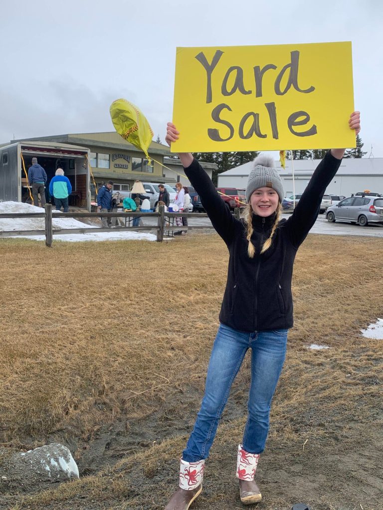 Homer High School freshman Hannah Klima holds a yard sale sign for the fundraiser for HHS Mariner softball on Saturday<ins>, April 15, 2023 in Homer, Alaska</ins>. (Photo by Christina Whiting)
