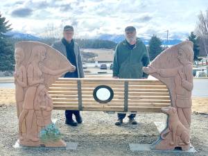 Homer artists Art Koeninger (left) and Brad Hughes (right) stand in front of the Loved and Lost Memorial Bench on April 26, 2023 during a ceremony in which the newly-installed lotus lamp was turned on. Photo by Christina Whiting