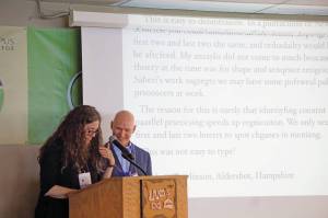 Homer poet and Kachemak Bay Writers Conference faculty member Erin Coughlin Hollowell, left, reads a passage that shows words can be understood even when the letters are garbled as 2018 keynote speaker Anthony Doerr watches. Doerr delivered the opening address at the start of the annual conference on June 5, 2018, at Lands End Resort in Homer, Alaska. (Photo by Michael Armstrong/Homer News)
