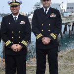 Lt. Cmdr. Russell Allen and Cmdr. Ryan Downing in front of the USS Momsen on May 3, 2023, at Homer's deep water dock. (Emilie Springer/ Homer News)
