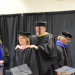 Kachemak Bay Campus Associate Professor of Psychology Brian Partridge (rear center) presents Laura Jean Miller (front center) with her masters hood during the 2023 KBC Commencement on Wednesday, May 10, 2023 in Homer, Alaska. Miller completed her Master of Public Health degree through University of Alaska Anchorage. (Photo by Delcenia Cosman/Homer News)
