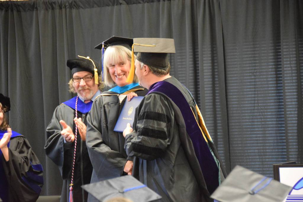 University of Alaska Fairbankss Dr. Peter Westley presents Dorothy Sherwood with her diploma and masters hood during the 2023 KBC Commencement on Wednesday, May 10, 2023 in Homer, Alaska. Sherwood earned her One Health Masters degree through UAF. (Photo by Delcenia Cosman/Homer News)