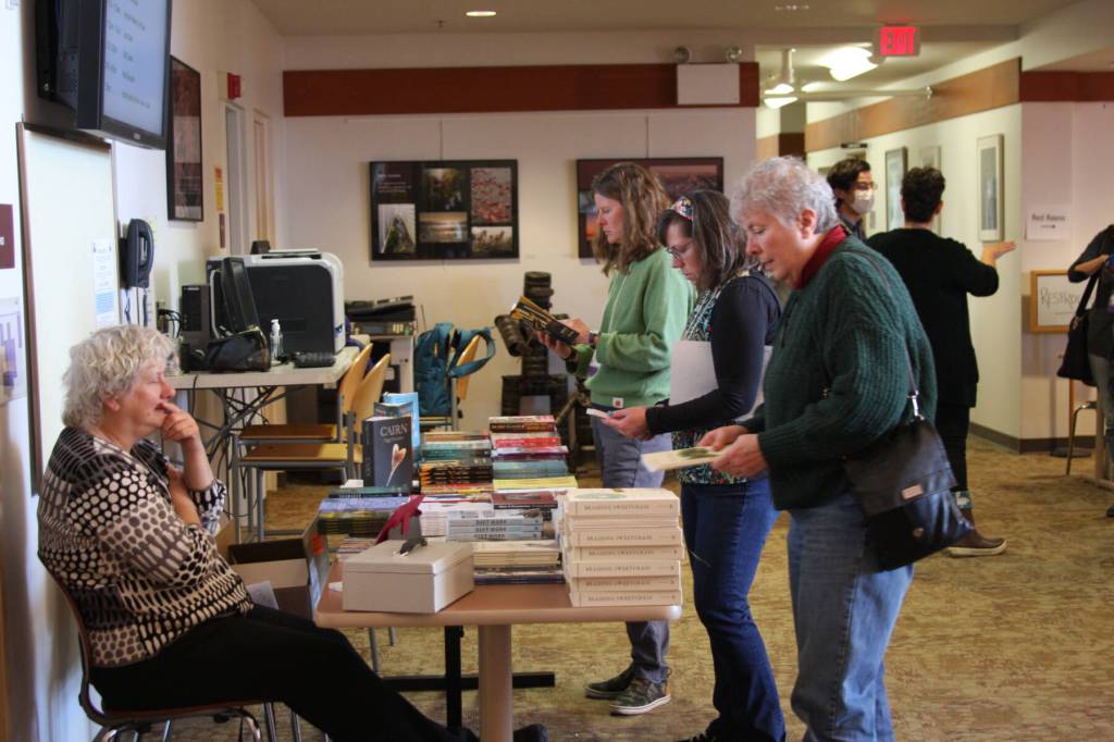 Kachemak Bay Writers Conference attendees purchase books by conference keynote and faculty on Saturday, May 13, 2023 at Kachemak Bay Campus in Homer, Alaska. Photo by Delcenia Cosman